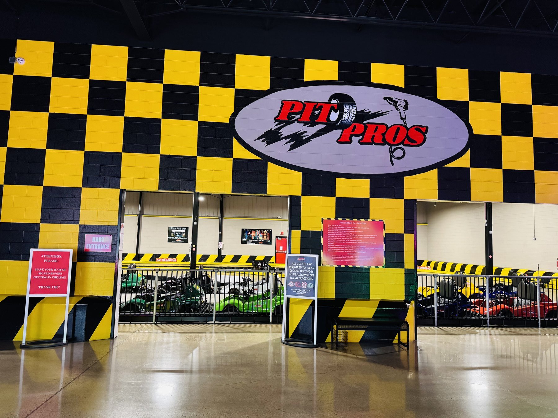 Pit Pros go-kart entrance at Play and Spin in Niles Illinois with yellow and black checkered racing wall