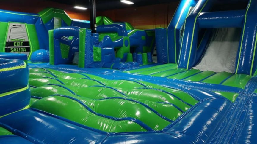 Inflatable bounce park floor with obstacles and slide at Play and Spin in Niles Illinois