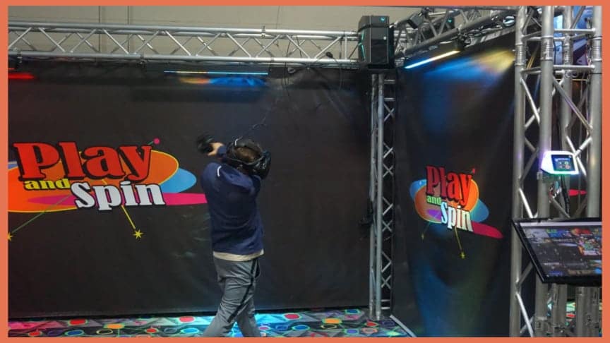 Player in VR headset at Play and Spin entertainment center in Niles Illinois with branded backdrop